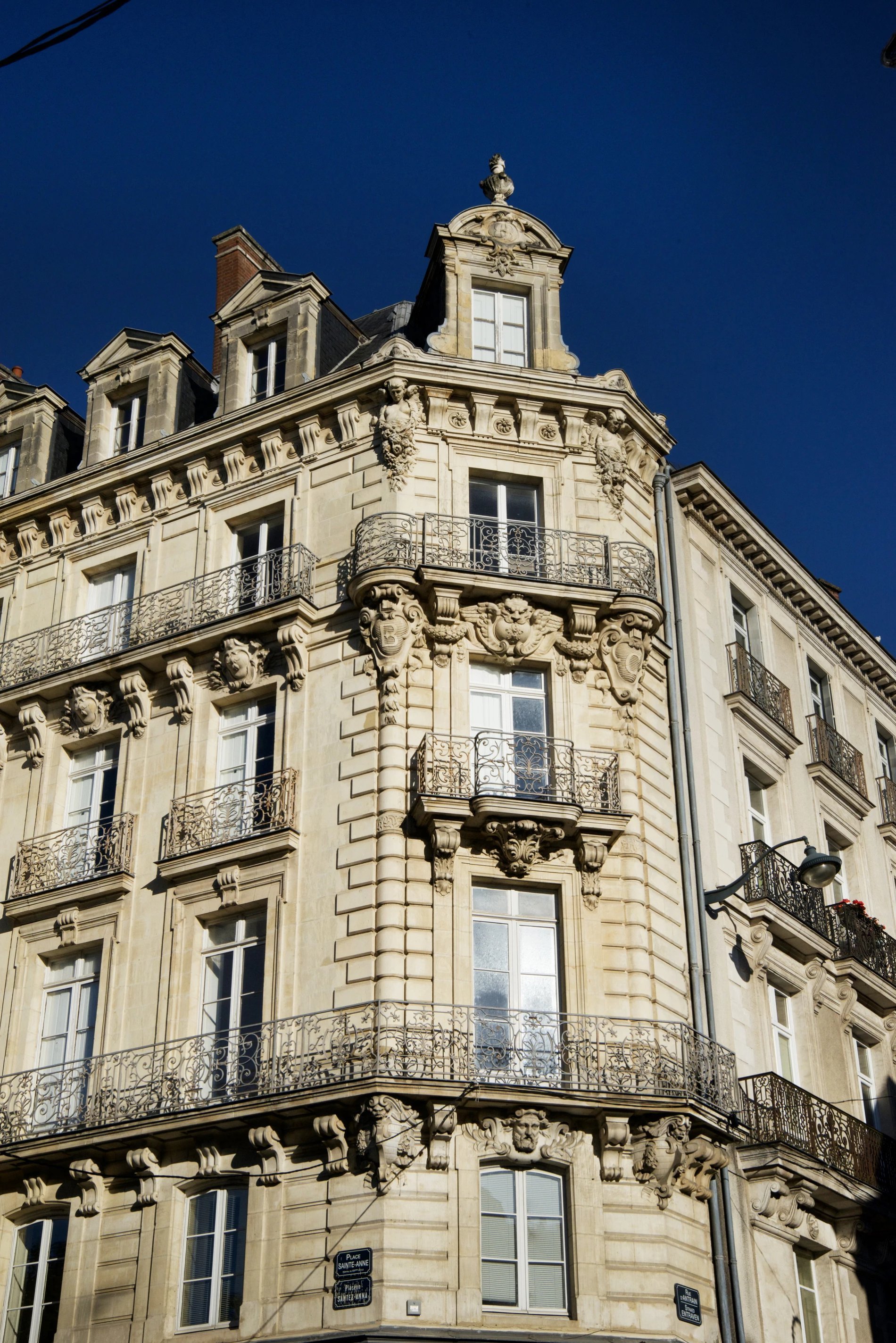 Façade architecturale typique de Rennes abritant Le Nemours Hôtel & Appartements sous un ciel bleu.