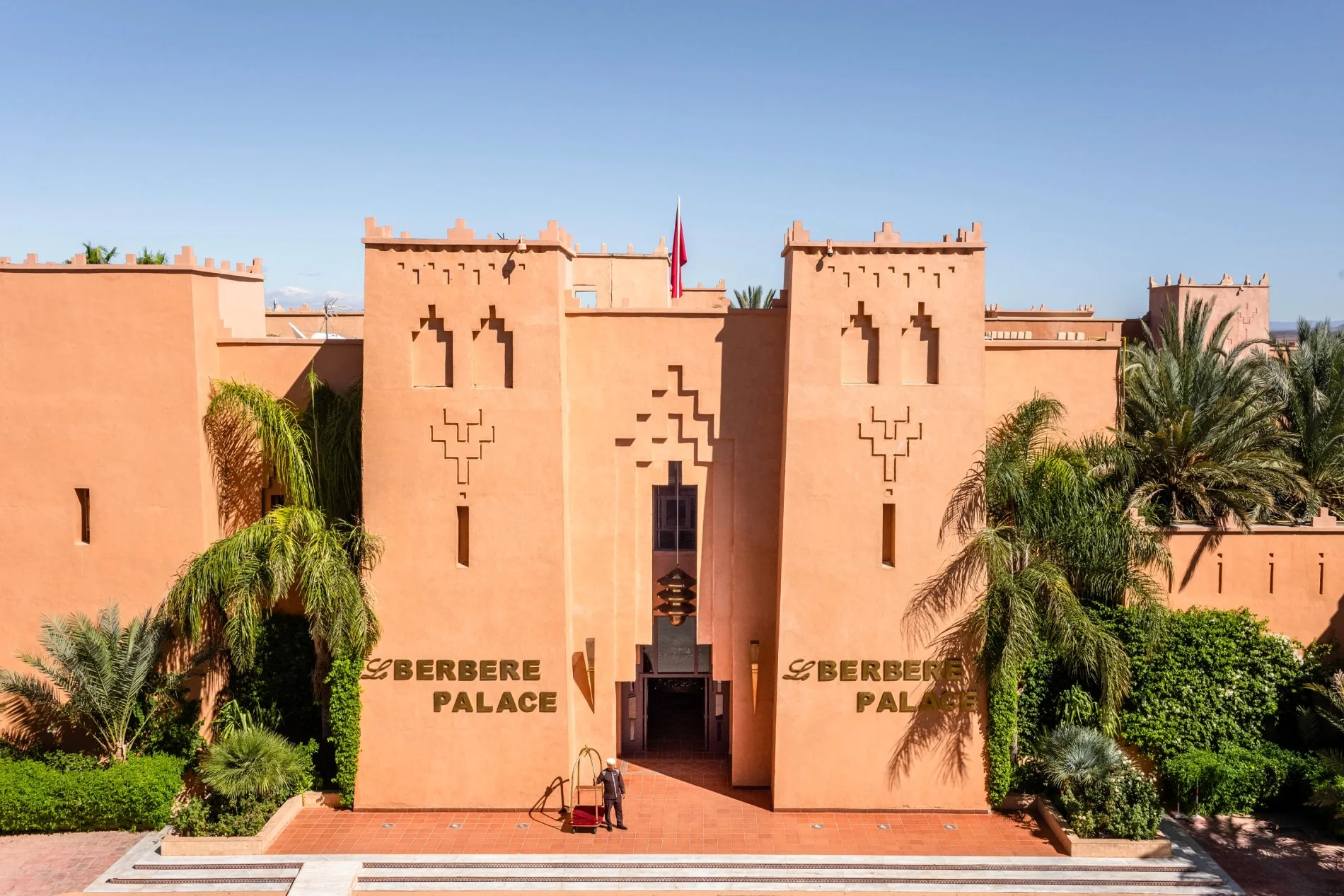 Façade principale du Berbère Palace à Ouarzazate avec palmiers