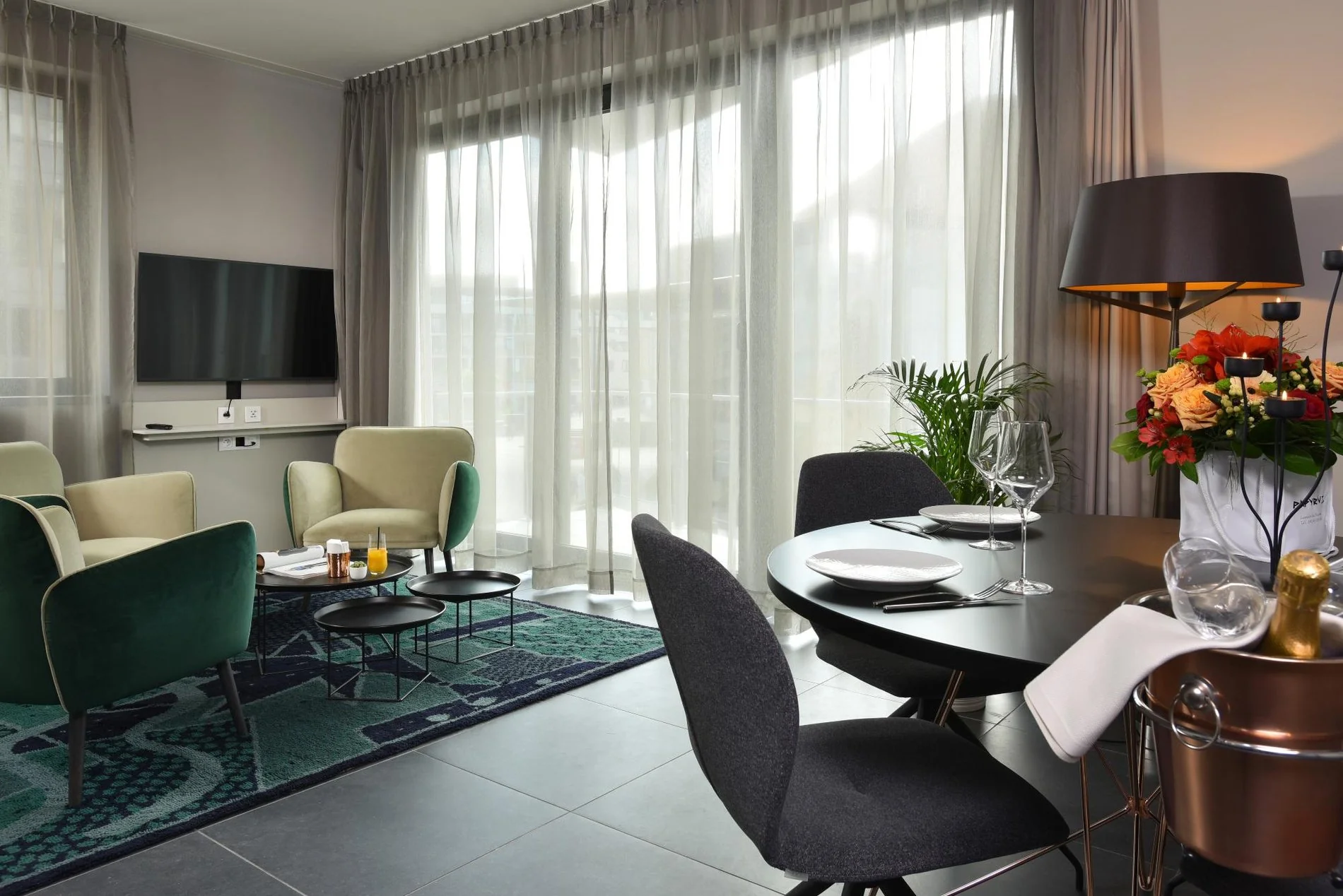 Salon lumineux avec coin repas, fauteuils et grande fenêtre