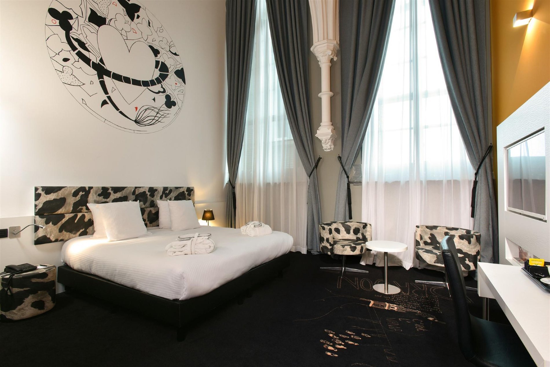 Elegantes Zimmer mit hoher Decke und Entspannungsbereich im Martin's Dream in Mons.