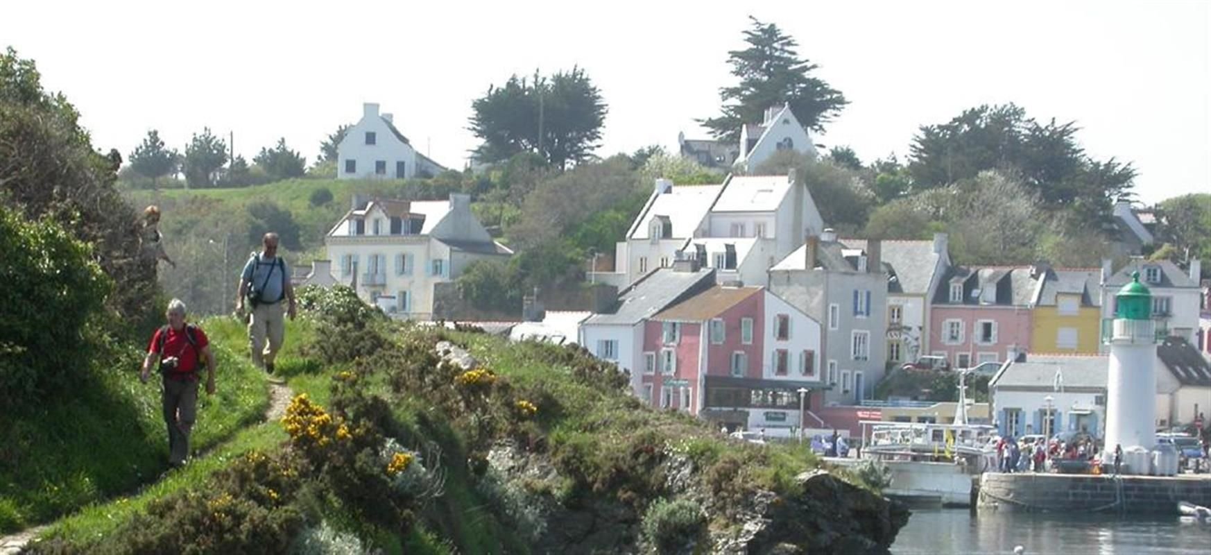 Randonneurs sur les sentiers côtiers de Belle-Île-en-Mer avec vue sur le port du Palais