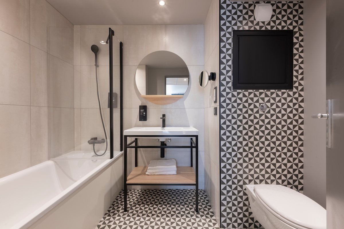 Salle de bains avec baignoire douche du studio supérieur Tulip Residences Joinville