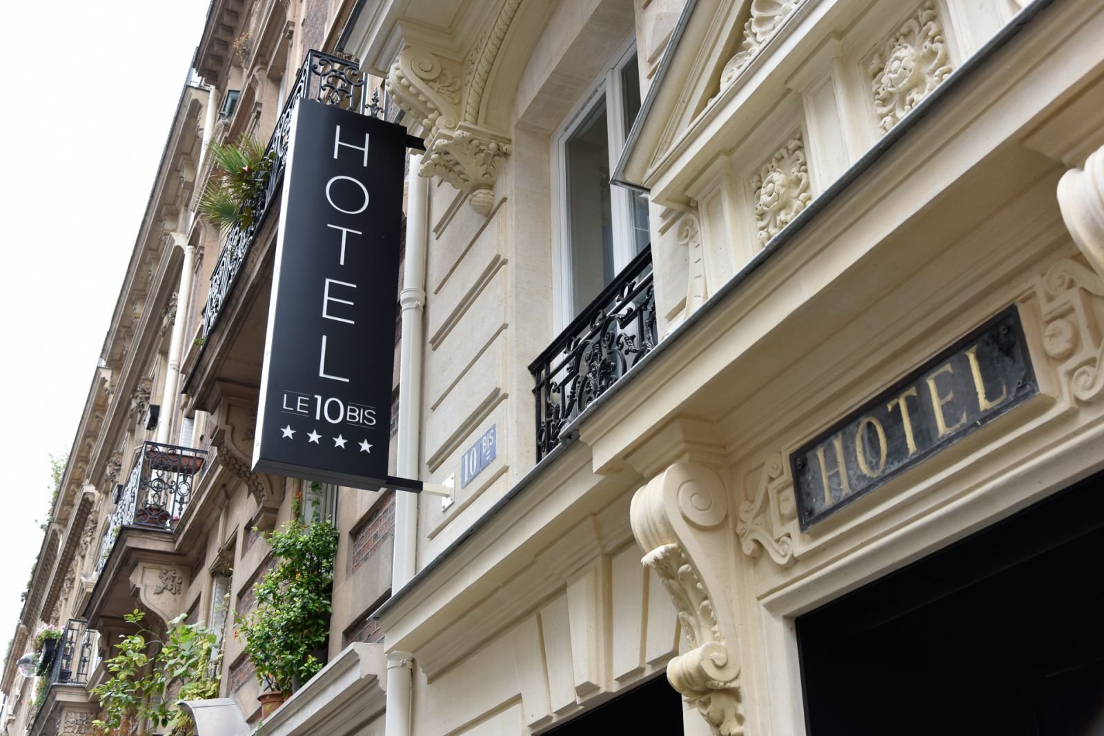 Façade de l'hôtel Le 10 Bis avec enseigne noire sur la rue du Débarcadère à Paris 17ᵉ